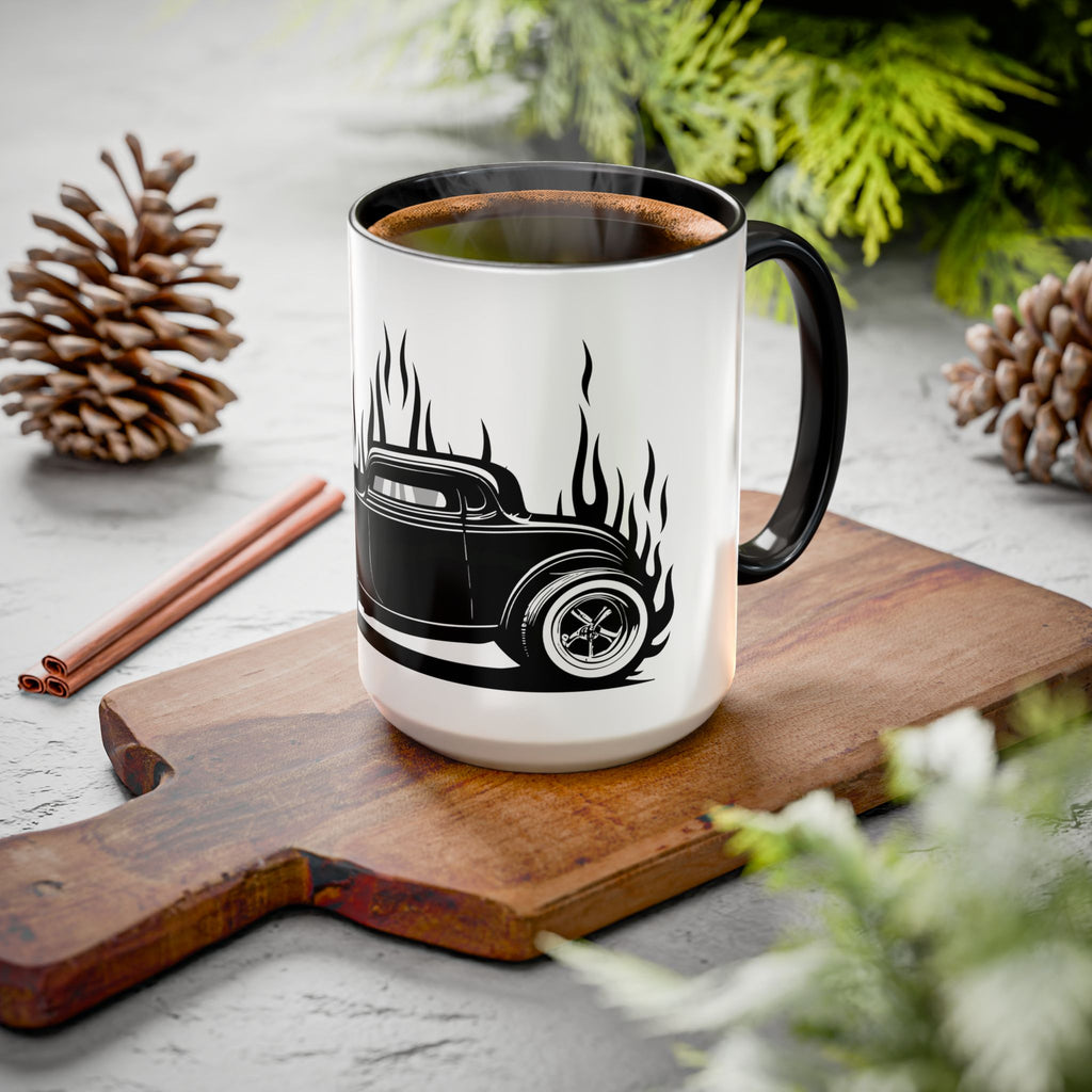 White mug with black handle featuring a hot rod design on a wooden cutting board with cinnamon sticks and pinecones.