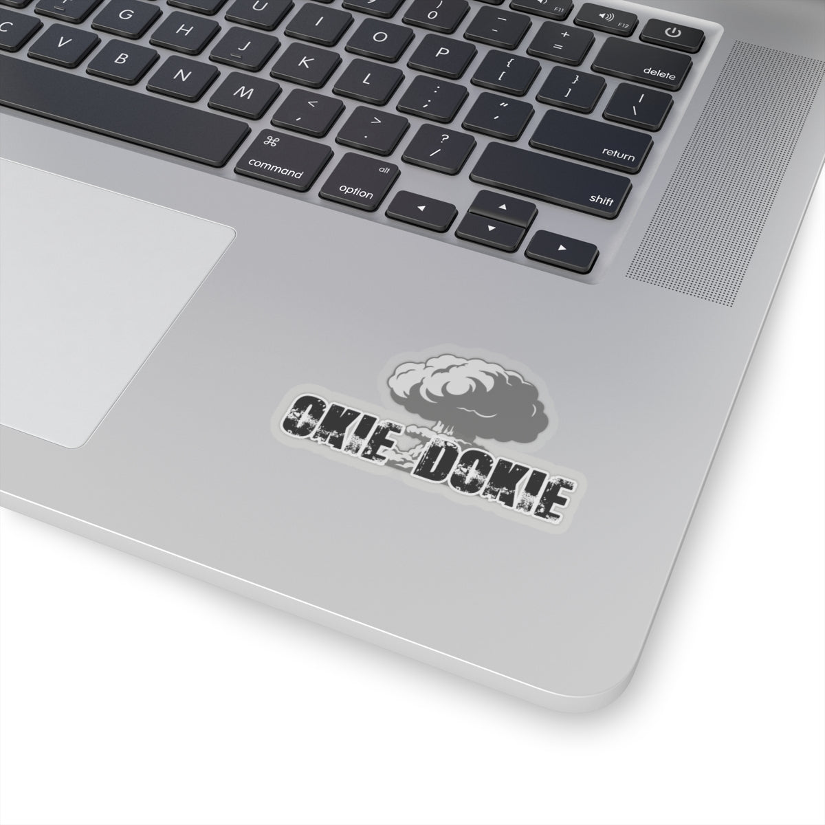 Laptop with a sticker on the palm rest area featuring a logo and okie dokie text.