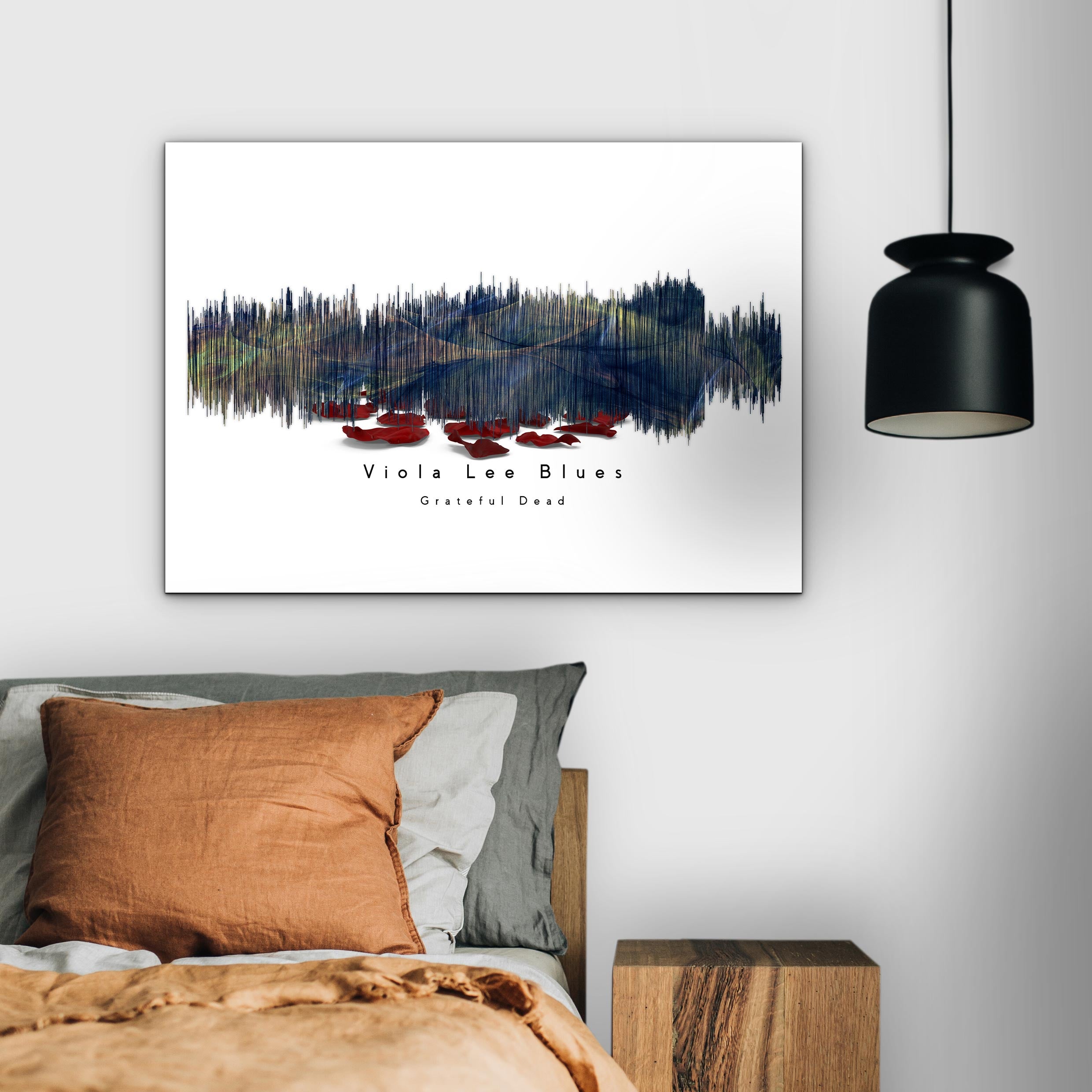 Framed artwork on a wall above a bed with a modern pendant light.