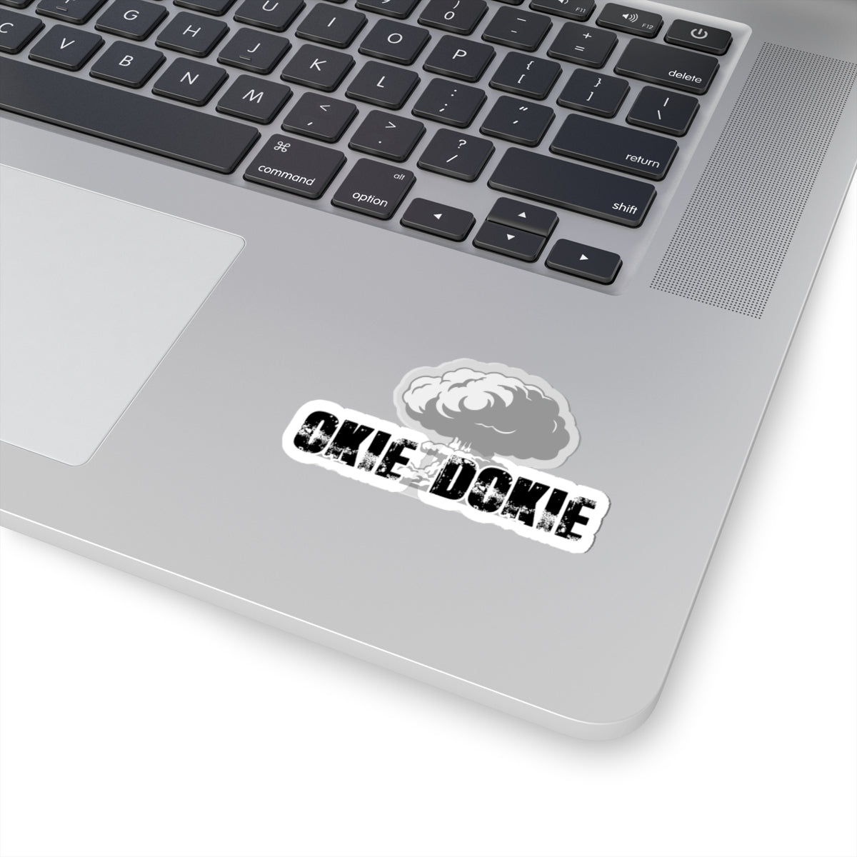 Laptop with a sticker on the palm rest area featuring okie dokie text and a logo.