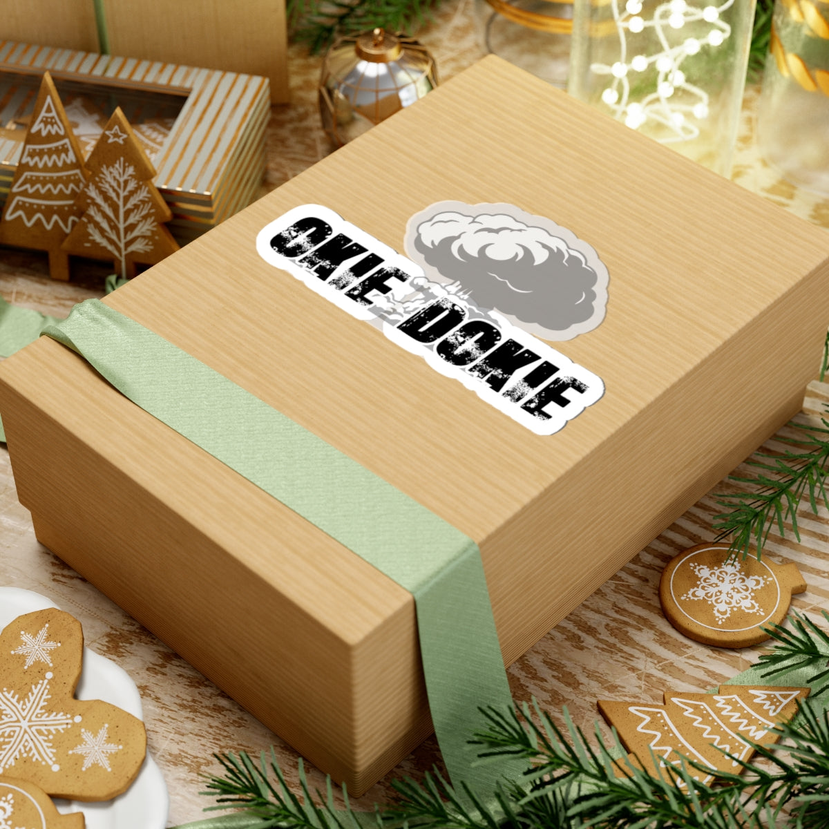 Wooden gift box with a green ribbon and 'okie dokie' label, surrounded by festive decor.