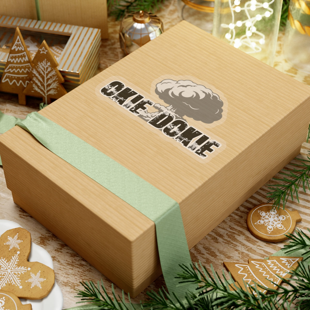 Wooden gift box with green ribbon and 'okie dokie' branding on a festive background with cookies and decorations.
