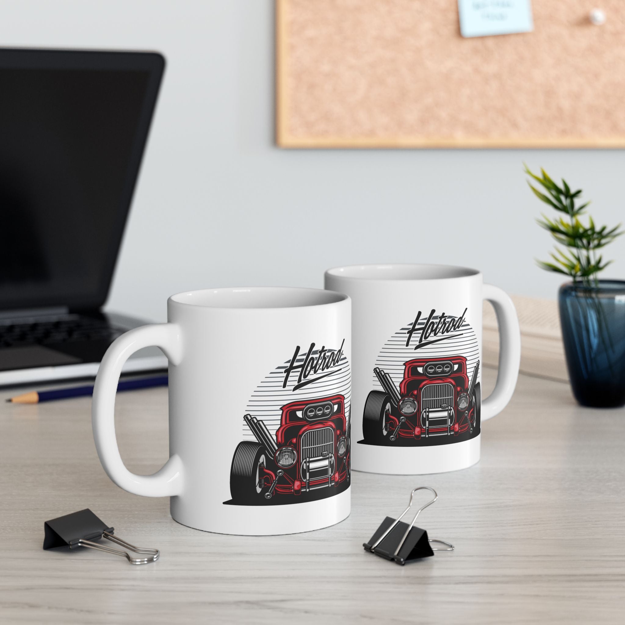 Two white mugs with hot rod design on a desk with office items.
