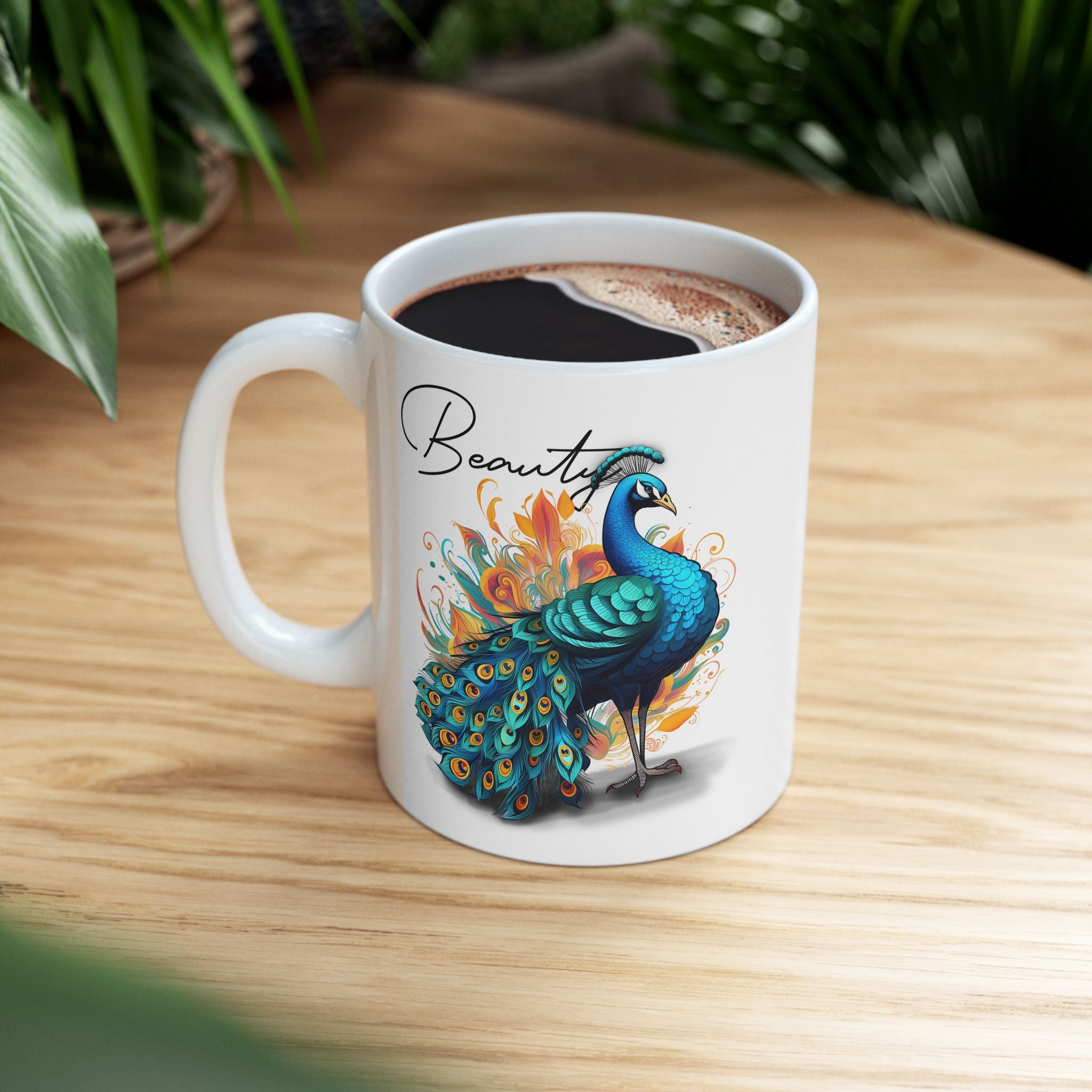 White mug with peacock design and 'Beauty' text on a wooden surface