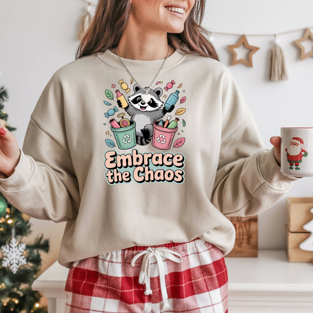 Person wearing a sweatshirt with a panda design and 'Embrace the Chaos' text, holding a mug in a festive setting.