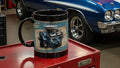 Blue and white muscle car in a garage with a mug featuring a Pontiac Ram Air IV engine on a red toolbox.