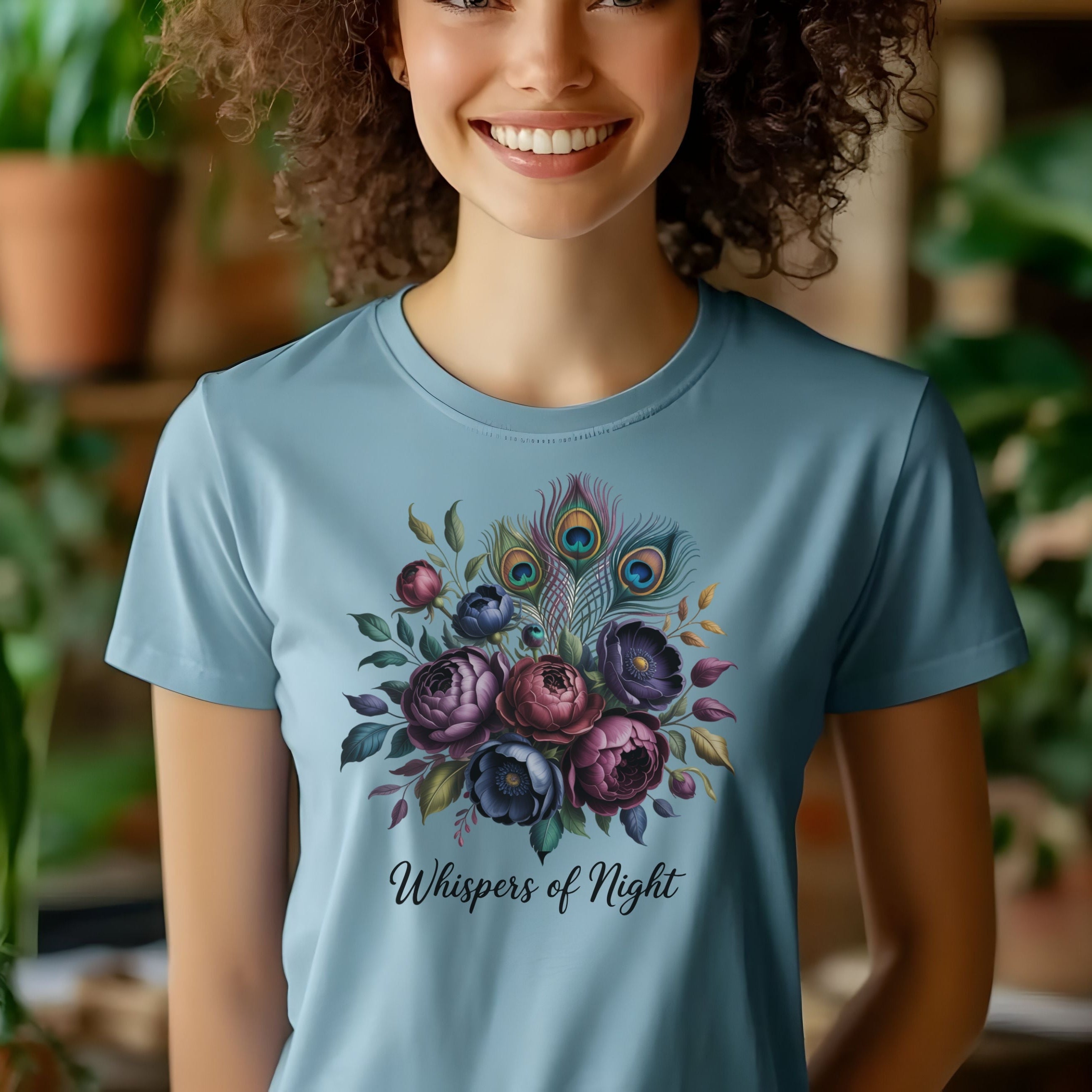 Person wearing a blue t-shirt with floral design and text in a plant-filled room