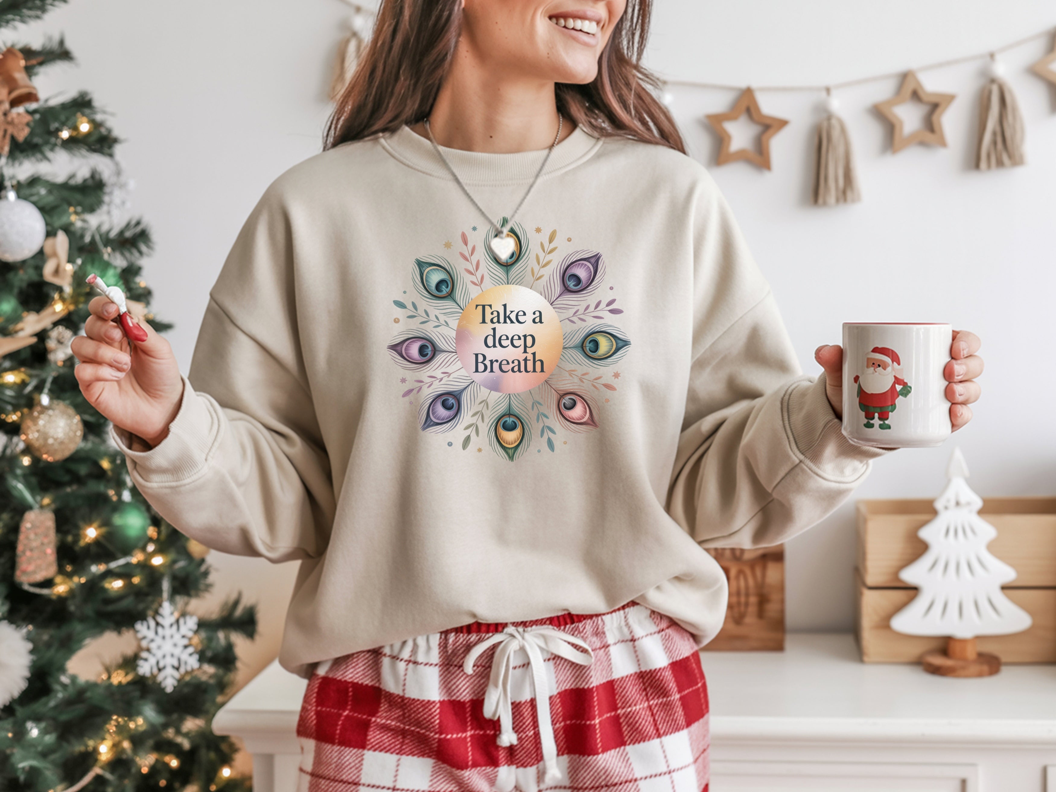 Person wearing a sweatshirt with a colorful design and text, holding a mug in a festive setting.