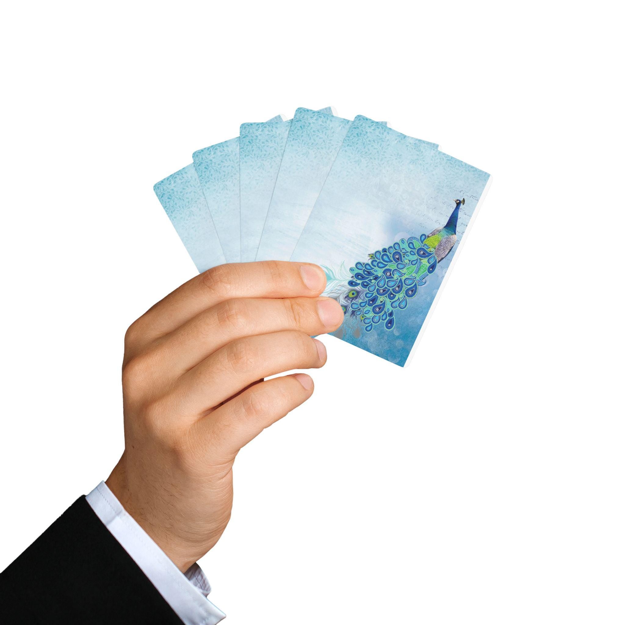 Hand holding Peacock Poker Deck cards with vibrant blue peacock feather design, ideal for card games.
