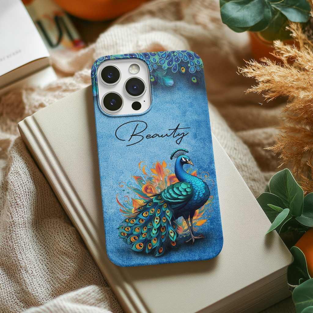 Tough protective blue peacock phone case on a book with 'Beauty' text, vibrant bird illustration