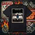 Black t-shirt with a car graphic and 'TRANS AM' text on a garage-themed background.